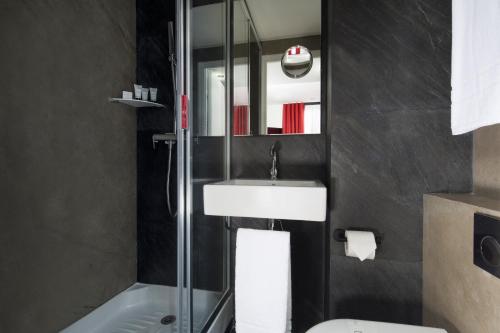 巴黎霹雳姆酒店的一间带水槽和淋浴的浴室