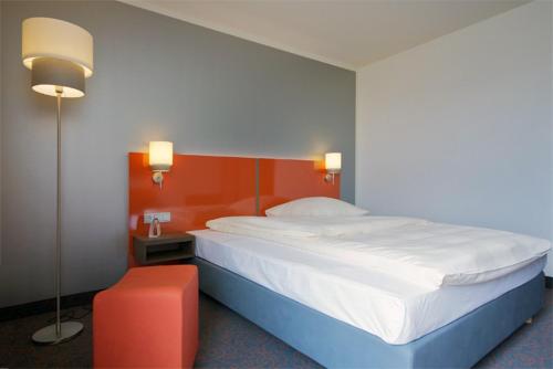 乌尔姆乌尔姆iQ酒店的一间卧室设有一张大床和红色的墙壁