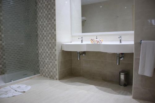 米多恩The Ksar Djerba Charming Hotel & SPA的浴室配有白色水槽和淋浴。