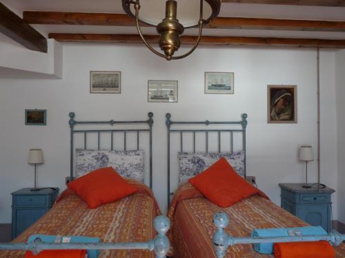 卡拉泰乌廖卡萨帝卡米拉住宿加早餐旅馆的卧室内的两张床和橙色枕头