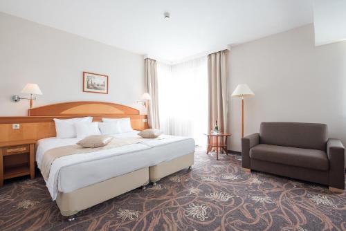 萨尔瓦尔萨尔瓦尔维塔尔梅德酒店的酒店客房带一张大床和一把椅子