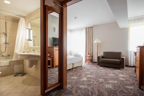 萨尔瓦尔萨尔瓦尔维塔尔梅德酒店的酒店客房设有带一张床和镜子的浴室