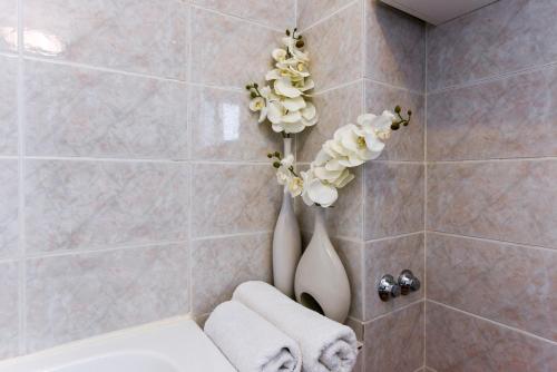 扎达尔乔拉克公寓的浴室配有卫生间,墙上挂有鲜花