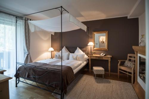 奥蒂塞伊哈特曼木屋酒店 - 仅限成人的一间卧室配有一张天蓬床和一张书桌