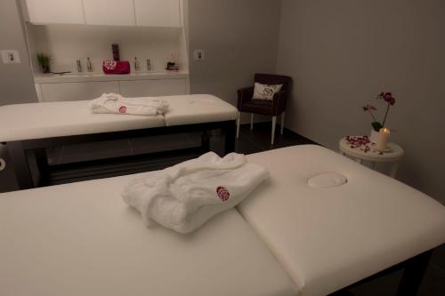 维达古布瑞玛锐欧香水酒店的一间设有两张床的房间,上面有白色的毛巾