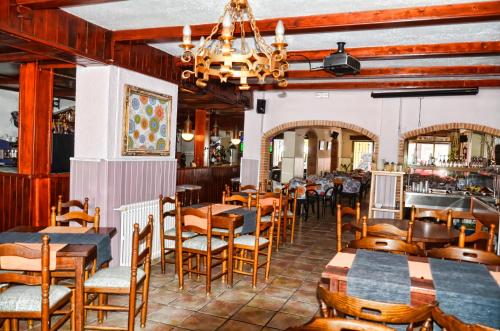 布拉内斯伊莎贝尔旅馆的一间带木桌椅的餐厅和一间酒吧