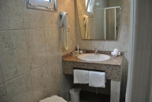 波尔图Hotel Peninsular- Porto的一间带水槽和镜子的浴室