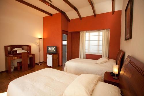 苏克雷安提瓜别墅酒店的酒店客房设有两张床和窗户。