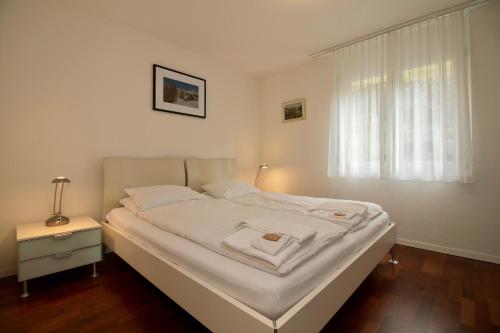 翁根Chalet Goldenhorn的卧室内的一张白色床,设有窗户