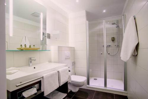 波恩梅塞德斯城市酒店的白色的浴室设有卫生间和淋浴。