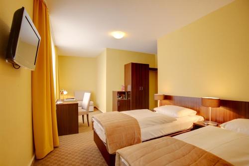 波恩梅塞德斯城市酒店的酒店客房设有两张床和一台平面电视。