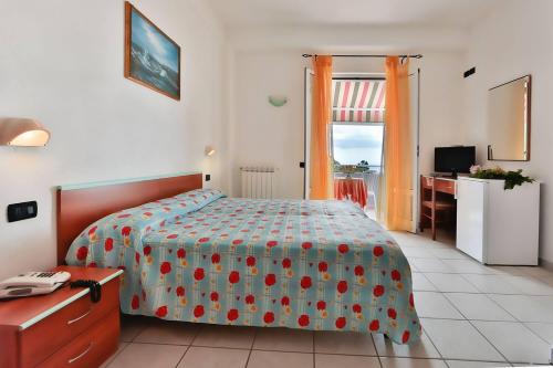伊斯基亚Hotel Villa Rita的一间卧室配有一张床、一张书桌和一个窗户。