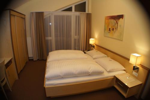 斯拉德明Hotel Sonneck的一间卧室配有一张带两个白色枕头的床