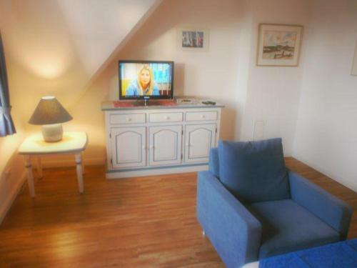 里斯特Westhof-7的客厅配有蓝色的沙发和电视