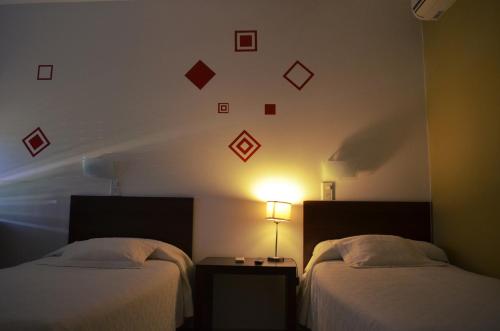 里奥夸尔托拉波萨达德尔维赫罗宾馆的酒店客房设有两张床和墙上的时钟。