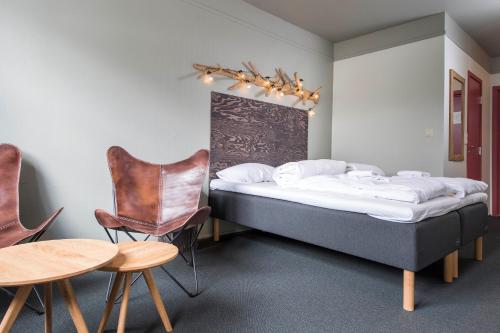 特吕西尔特利西尔酒店的一间卧室配有两张床和一张桌子及椅子