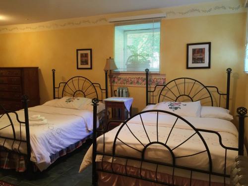 温哥华鲍尔弗旅馆的卧室设有两张黄色墙壁的床