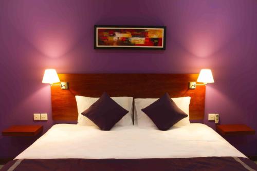 圣吉吉Melasa House的卧室配有白色床和紫色墙壁
