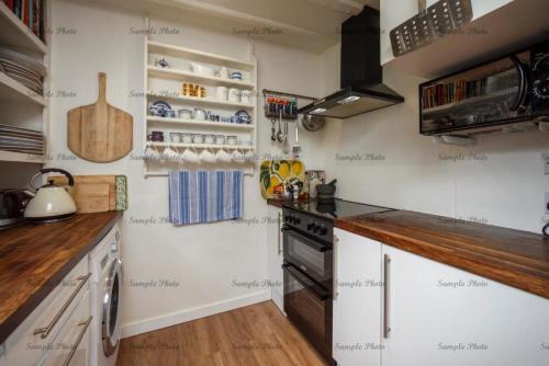梅德斯通The Buttery的一间小厨房,配有白色的墙壁和木制柜台