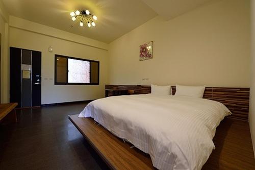 鹿谷乡山中悠游民宿的卧室设有一张白色大床和一扇窗户。