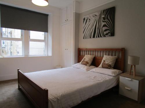 格拉斯哥Westend Glasgow Apartment的卧室配有一张床,墙上挂着斑马图
