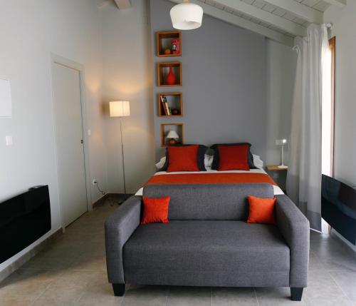 帕拉斯德丽Galpon Boutique Aldea De Abaixo的一间卧室配有一张床和一张带橙色枕头的沙发。