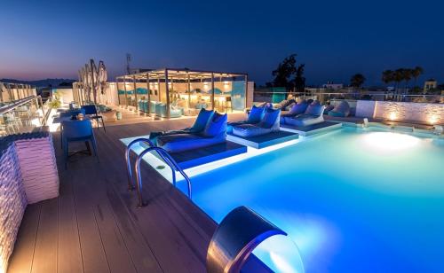 科斯镇玛丽提娜酒店的夜间在建筑物屋顶上的游泳池