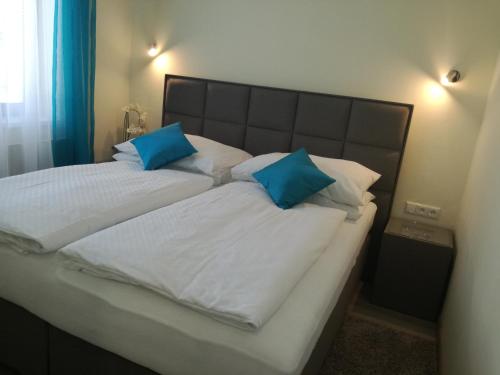 特伦钦garni Hotel S.O.G.* * *的床上有2个蓝色枕头