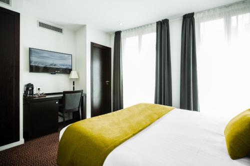 巴黎拉内公园酒店的配有一张床和一张书桌的酒店客房