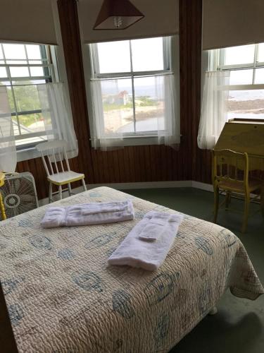 Peaks IslandThe 8th Maine Regiment Lodge and Museum的卧室配有带窗户的床上的2条毛巾