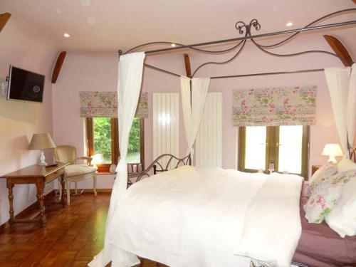 Montignies-le-TilleulLe chateau des eglantines的一间卧室配有一张带天蓬的白色床