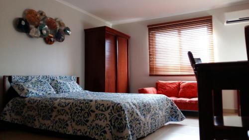 棕榈滩Dorado Eagle Beach Hotel的卧室配有床、椅子和窗户。