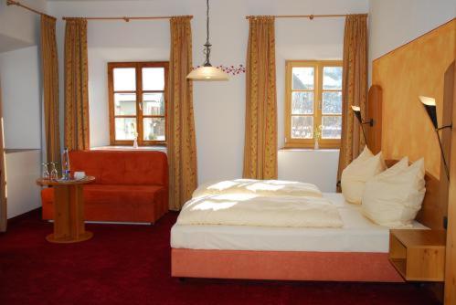 希格斯多夫阿尔特帕斯特酒店的一间卧室配有一张床、一把椅子和窗户。