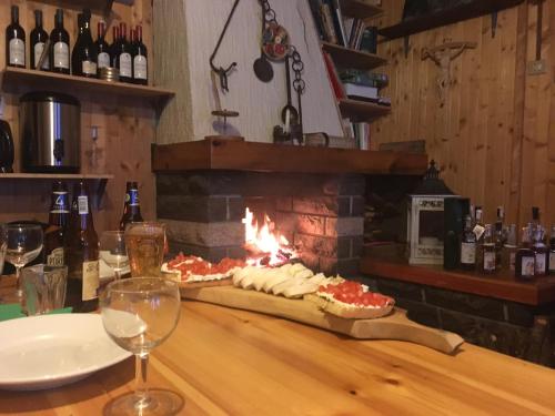 圣雅克Rifugio Guide Frachey的壁炉前的餐桌,包括2份比萨饼