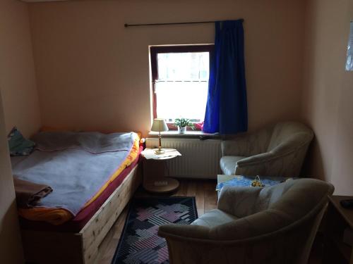 汉堡格罗高尔迷人度假屋的一间卧室配有一张床、两把椅子和一个窗户