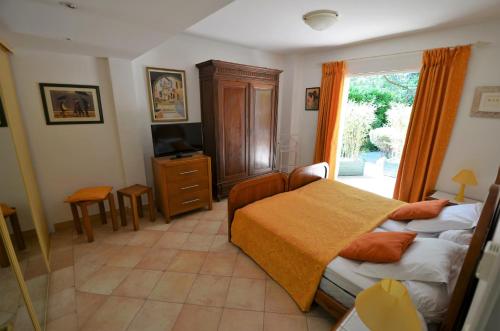 圣保罗-德旺斯Au vallon rouge (Suite double)的一间卧室设有两张床、一台电视和一扇窗户。