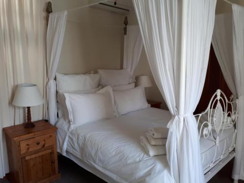 格拉夫-里内特De Kothuize 10的白色的床、白色窗帘和木制床头柜