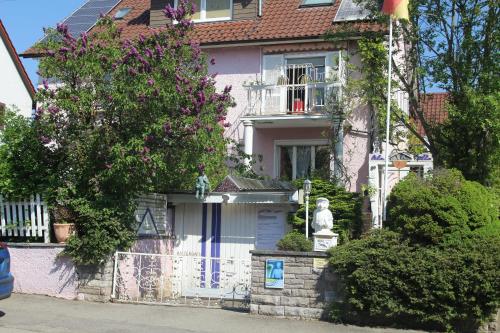 菲林根-施文宁根Lila Villa Schwenningen的前面有雕像的白色房子