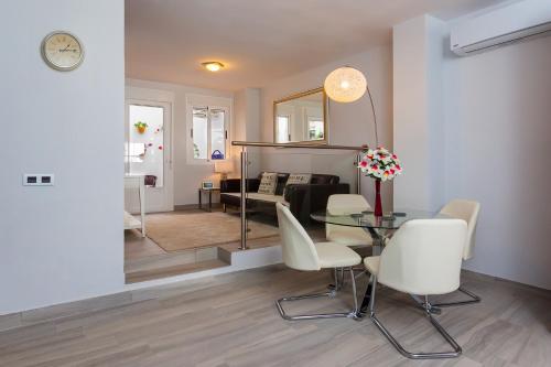 阿达莱斯Apartamento Vadim的客厅配有玻璃桌和白色椅子