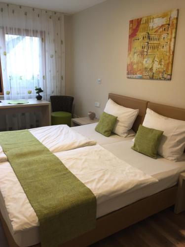 特里尔沃尔斯切德旅馆的一间卧室配有一张带绿色和白色床单的大床