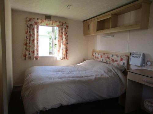MetheringhamFenlake holiday accommodation的一间小卧室,配有床和窗户