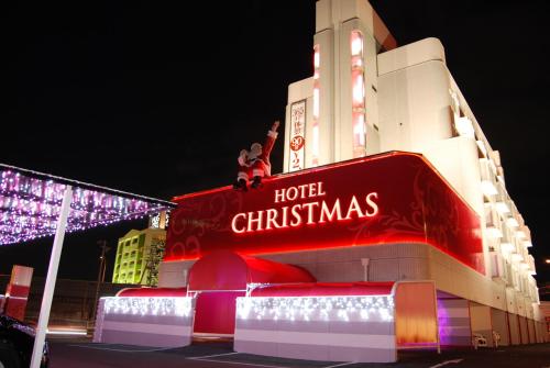 InazawaHotel Christmas (Leisure Hotel)的两人坐在酒店圣诞标志的顶端