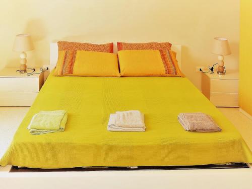 迪索Oikia Vacanze Diso Giulia的黄色的床,上面有两条毛巾