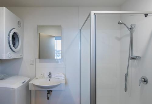 奥克兰科斯特亨森特服务式公寓的带淋浴和盥洗盆的白色浴室