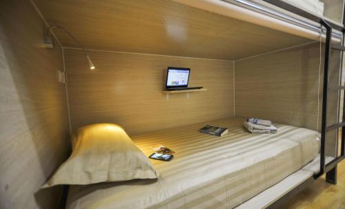 乌兰巴托蒙古观光旅游宾馆的墙上配有电视的房间里一张床位