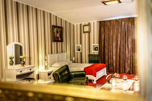 布加勒斯特Vila Sia的一间卧室配有一张床、一张沙发和一把椅子