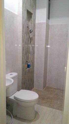 泗水SWK95号酒店的浴室配有白色卫生间和淋浴。