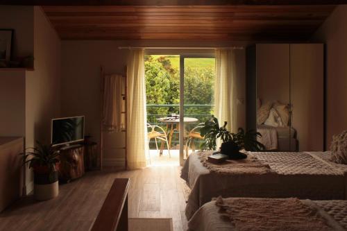 VárzeaVilla Várzea Nomad Nest的一间卧室设有两张床,并设有一个通往庭院的门。