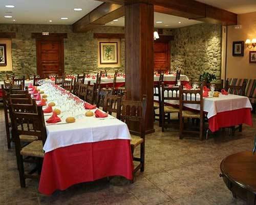 埃里斯特特莱斯皮克斯酒店的餐厅的一排桌子,上面有红白桌布