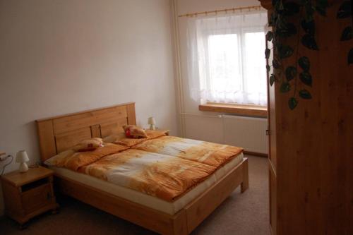 阿德尔什帕赫Apartman Horni Adrspach的一间卧室配有一张木床和窗户